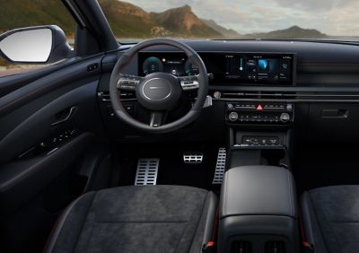 Cockpit Hyundai TUCSON N Line met zicht op stuurwiel, dashboard en middencolsole.