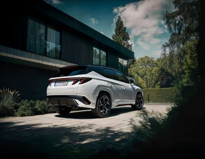 Hyundai TUCSON N Line zaparkovaný před domem.