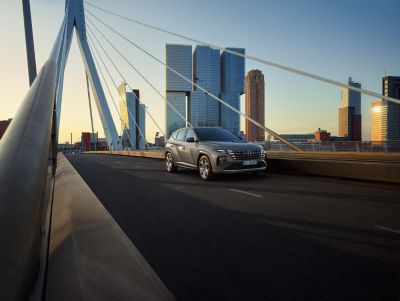 Hyundai TUCSON Hybrid corre su strada di città dopo un temporale
