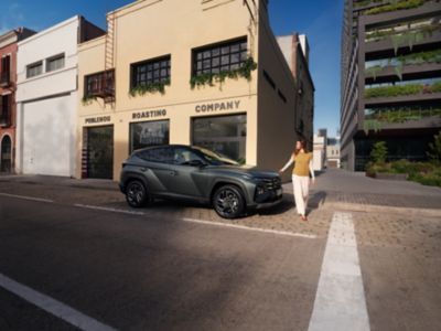 Nuova Hyundai TUCSON parcheggiata davanti un edificio moderno