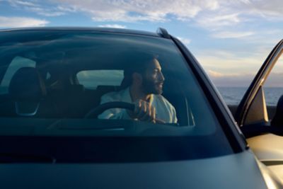 A man holding the steering wheel inside the Hyundai TUCSON 20th Anniversary Edition.	