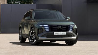 Le Hyundai TUCSON Hybrid est garé devant un bâtiment. 