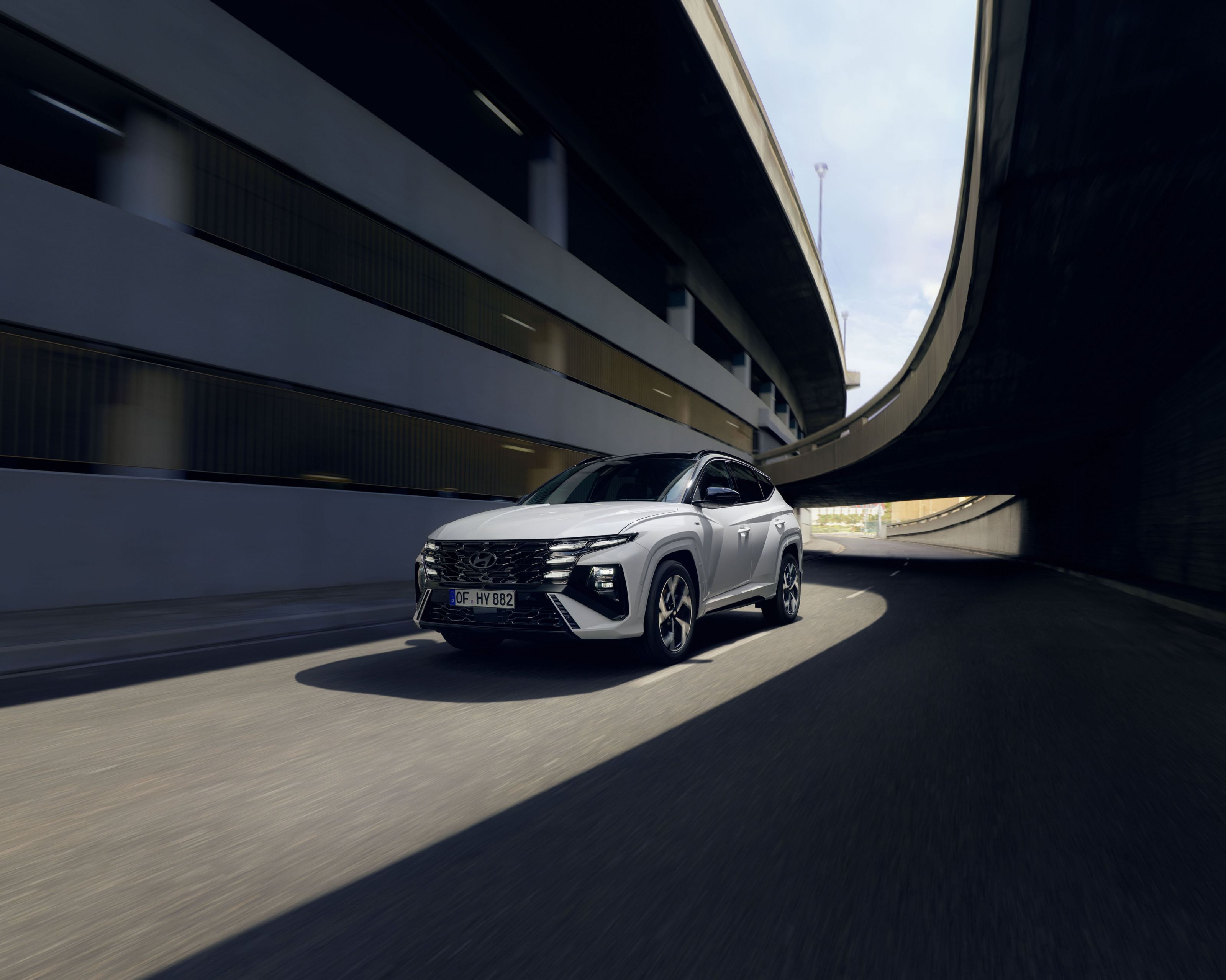 The Hyundai TUCSON Plug-in Hybrid driving down a city street.