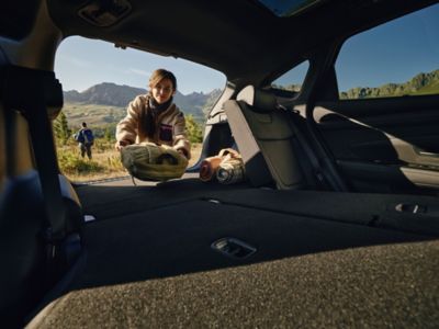 A woman putting things in the boot space of the Hyundai TUCSON Plug-in. 