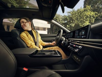 A woman in the driver's seat of the the Hyundai TUCSON Plug-in Hybrid.