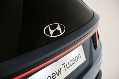 Gładkie szklane logo Hyundai z tyłu nowego kompaktowego SUV-a Hyundai TUCSON Plug-in Hybrid.