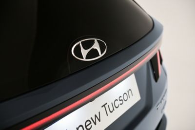 Logo av glass bak på helt nye Hyundai TUCSON Plug-in Hybrid SUV. Foto.