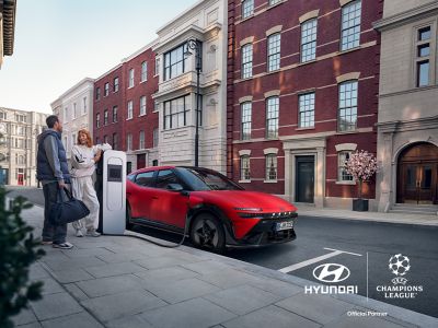 A man and a woman eating take out food in the front seats of the Hyundai IONIQ 3.  