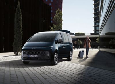 A man walking away from the smart power tailgate of the Hyundai STARIA multi-purpose vehicle.