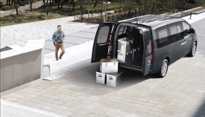 The all-new Hyunday STARIA Van with boxes being loaded into its ample cargo space.