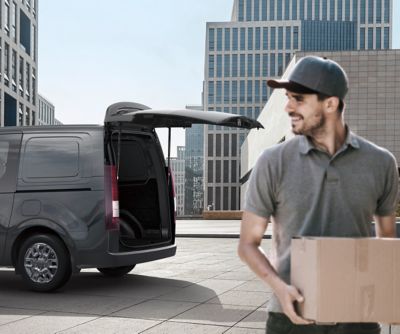 A man unloading the Hyundai Hybrid STARIA Van.