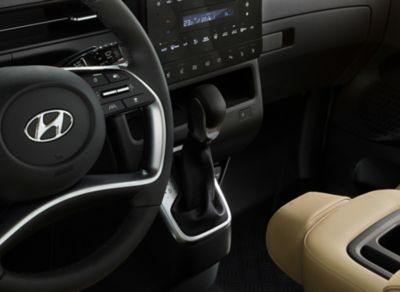 A detailed view of the STARIA's driving wheel and stylish gearshift in the centre console.