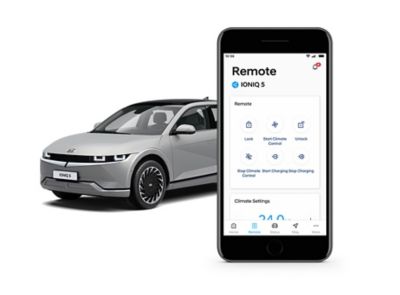 Hyundai IONIQ 5 dietro uno smartphone che mostra l’app Bluelink