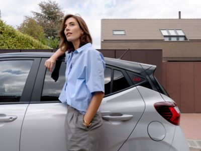 A woman leaning on the side of the Hyundai i10 N Line.