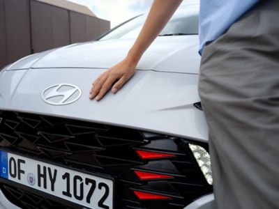 A close up of a woman's hand leaning on the hood of the Hyundai i10 N Line.