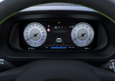 A man in the driver's seat operating the touchscreen of an Hyundai i20 while driving. 