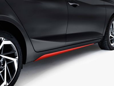 The side skirts accessories highlighted in tomato red on the Hyundai i20.