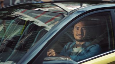 A man looking at the camera from inside the cabin of a Hyundai i20.