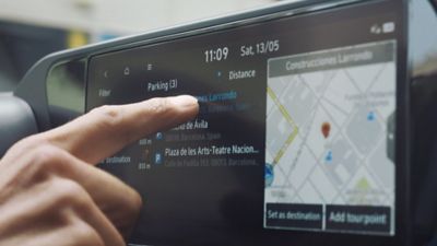 De vinger van een persoon op het touchscreen van de nieuwe Hyundai i20. 