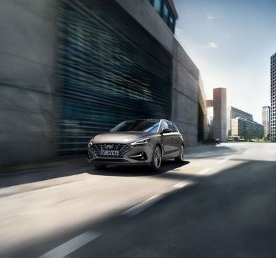 The Hyundai i30 drivig in a concrete street.