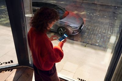Woman looking outside the window at the Hyundai i30. 