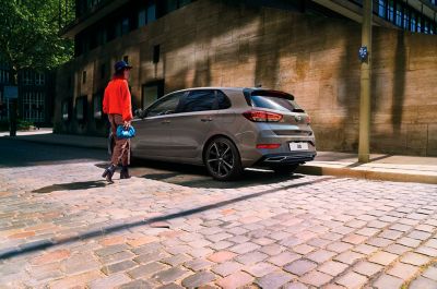 The Hyundai i30 parked on a cobblestone road seen from the side.	