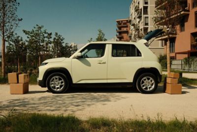 Hyundai INSTER VAN con il bagagliaio aperto, in una strada della città.