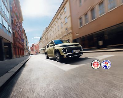 Une femme se tenant debout contre un lampadaire devant le mini SUV électrique compact Hyundai INSTER.