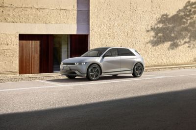 IONIQ 5 står parkert foran et moderne bygg. Foto.