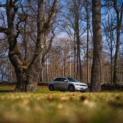 Elbilen IONIQ 5 parkert i skogen. Foto.