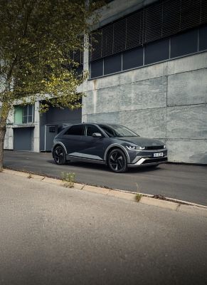 IONIQ 5 står parkert foran et moderne bygg. Foto.
