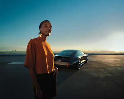 Une femme debout devant un concept car Hyundai 100% électrique.