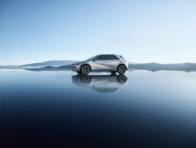 The Hyundai IONIQ 5 electric vehicle pictured from the side in a beautiful location.