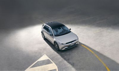 Vista di tre quarti della Hyundai IONIQ 5 dall'alto, parcheggiata, e un uomo che si allontana.