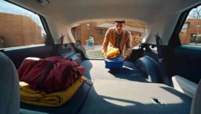 A man loads the trunk of his Hyundai IONIQ 5 with folded rear seats.