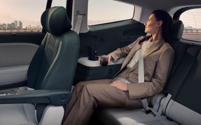 Eine Frau trinkt Kaffee im Innenraum des IONIQ 9.