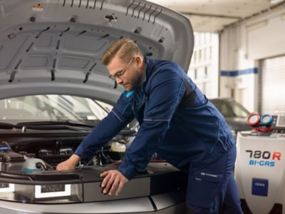 Un meccanico Hyundai ispeziona il sistema dell'aria condizionata in officina.