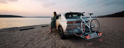 Hyundai IONIQ 5 parcheggiata davanti a una spiaggia con tramonto