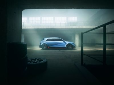 Hyundai IONIQ 5 N auto sportiva 100% elettrica, vista di lato e illuminata dal sole in un garage