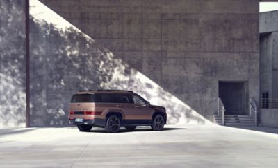 Hyundai Santa Fe parcheggiata davanti a un grande muro sotto il sole.