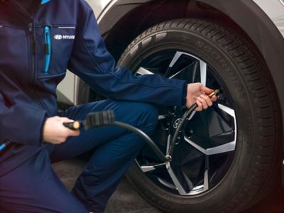 Assistente Hyundai controlla lo pneumatico di un modello Hyundai