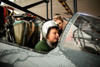 Student sitting inside an RAF aircraft with a helmet on.