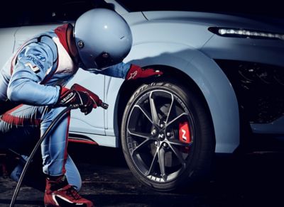 A pitstop mechanic checking the tire of a Hyundai KONA N.