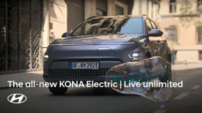 De Hyundai KONA Electric rijdt op straat terwijl er een zeepbel voorbij komt.
