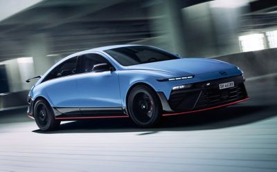 La Hyundai IONIQ 6N traverse une structure moderne, mettant en valeur son agilité et ses performances.