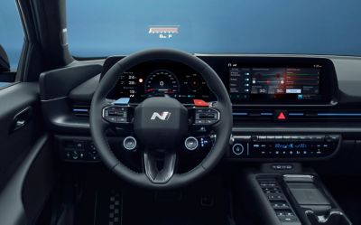 Interno della Hyundai IONIQ 6 N con abitacolo, display digitali e comandi orientati verso il conducente.