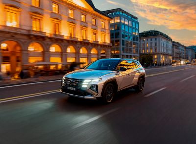 Nuova Hyundai TUCSON corre accanto ad un corso d'acqua in ambiente cittadino