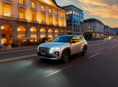 Nuova Hyundai TUCSON parcheggiata davanti un edificio moderno