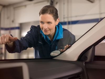 A Hyundai technician checking the windshield of a Hyundai vehicle