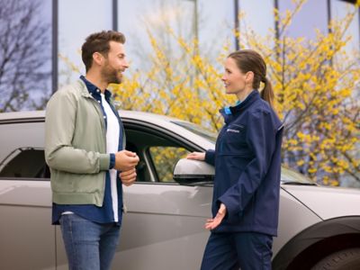 Une conseillère discutant avec un homme à coté de IONIQ 5